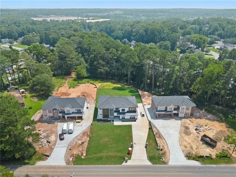 Existing MNVG project photograph showing three homes and a wooded backdrop in Lawrenceville